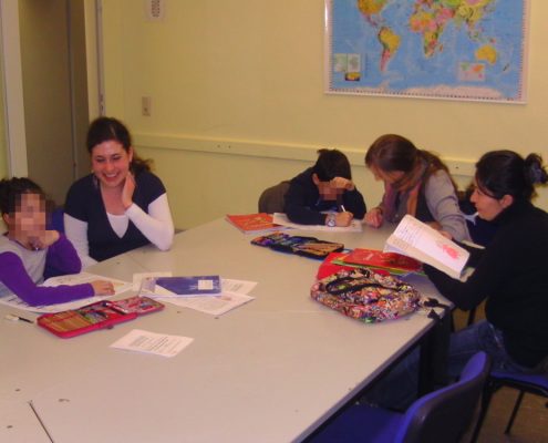Mehrere Kinder sitzen an einem Tisch und lernen deutsch