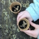Kinderhände halten einen Pflanztopf mit Erde und Samen. Ab ins Beet !